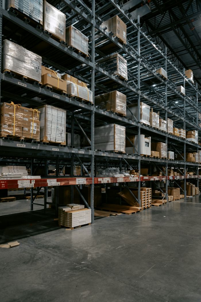 About A well-organized industrial warehouse with stacked shelves and various pallets for efficient storage.