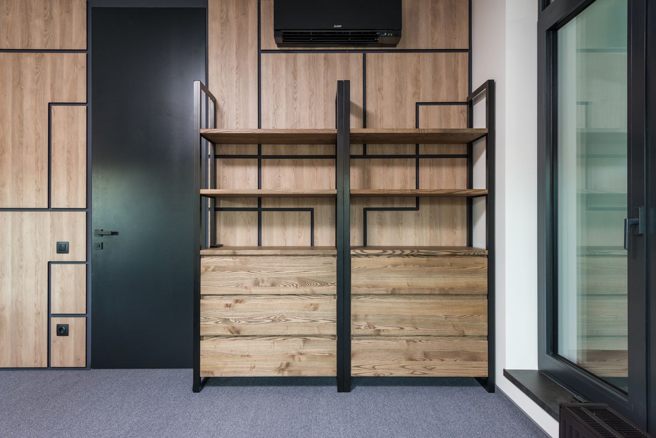 Modern room interior with wooden shelves under air conditioning between black door and window in light house